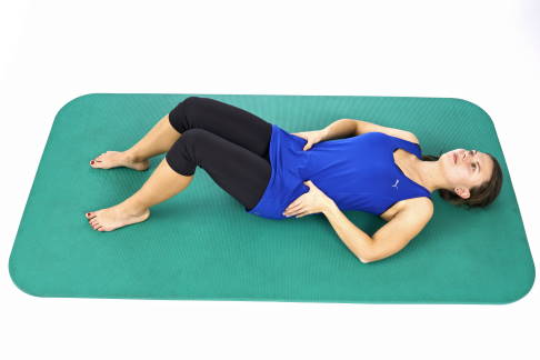 In Rückenlage mit angestellten Beinen spannen Sie den unteren Bauch und die Muskeln des Beckenbodens an.