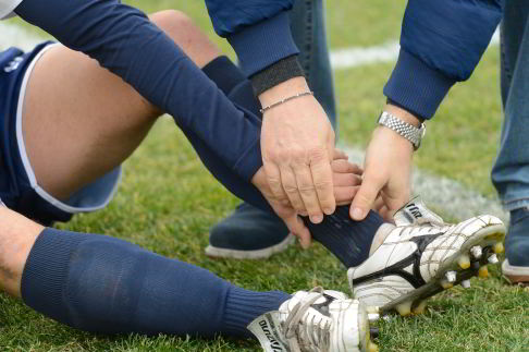 Verletzter Athlet mit Knöchelverletzung beim Fußball.