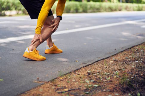 Läufer hat Schmerzen in der Achillessehne beim Joggen