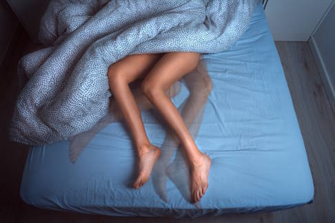 Frau schläft unruhig aufgrund von Fersenschmerzen