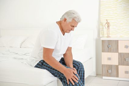Älterer Mann mit Knieschmerzen nach dem Aufstehen (Anlaufschmerzen)