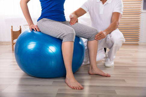 Assistives Bewegen: Der Physiotherapeut unterstützt den Patienten bei der Bewegung.