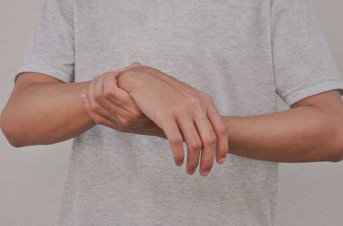 Bei einer Hemiparese betrifft die Lähmung nur eine Körperseite. Im Gegensatz zur Hemiplegie handelt es sich hierbei um eine inkomplette Lähmung. © Verin, Adobe Patient stützt gelähmten Arm mit dem anderen Arm
