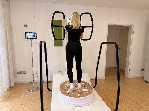 Patientin trainiert auf dem HUBER 360 zur neuromuskulären Analyse von Kraft, Koordination und Gleichgewicht