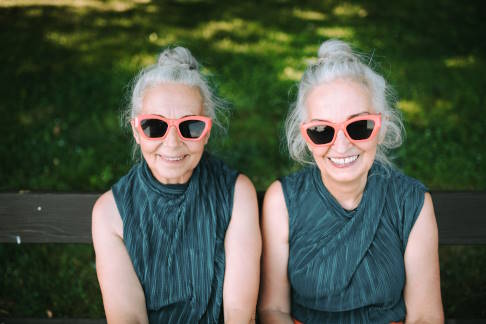 Weibliches Zwillingspärchen im vorgerückten Alterund  mit gleicher Bekleidung