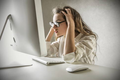 Frau am Computer mit Mausarm