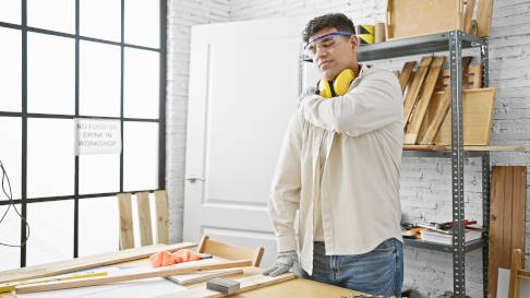 Mann mit Schulterschmerzen bei der Arbeit