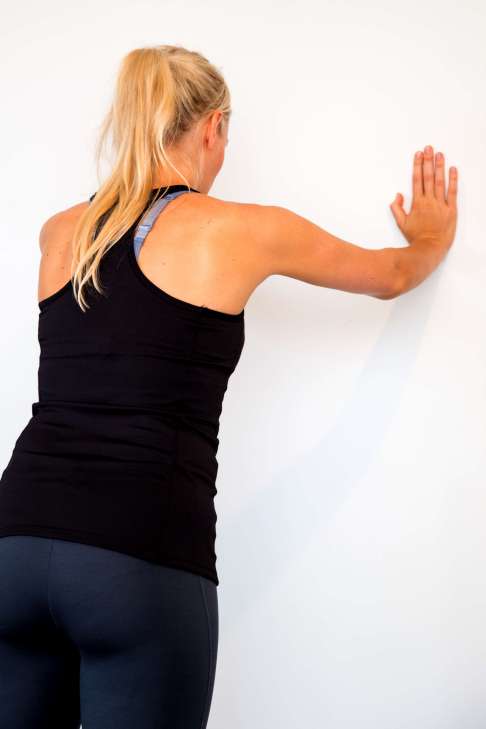 Brustkorb von der Wand wegdrücken kräftigt die Schultermuskulatur und zentriert die Schulterblätter.